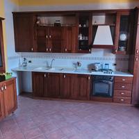 cucina componibile con vetrina e due divani