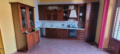 cucina componibile con vetrina e due divani