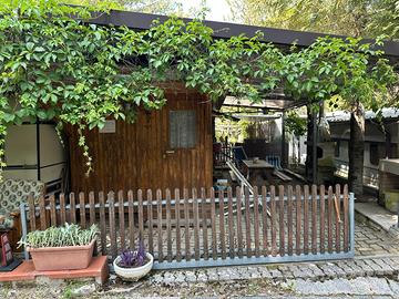 Villetta legno con roulotte in camping