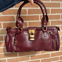 Borsa color bordeaux con dettagli oro
