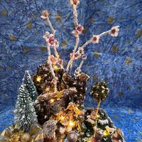 Presepe natalizio con luci e rami di pesco
