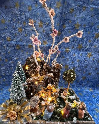 Presepe natalizio con luci e rami di pesco