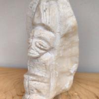 Scultura di un idolo antico su pietra calcarea