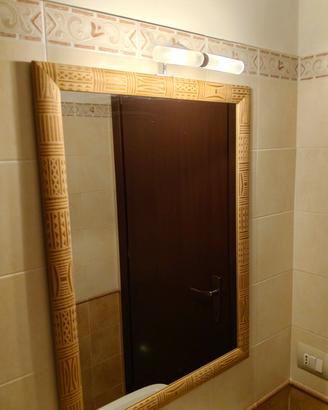 Specchio da bagno con cornice lavorata e faretto