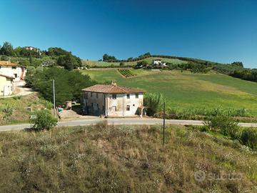 Casale toscano con terreno e vista sulle colline