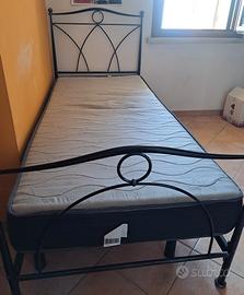 letto singolo in ferro battuto munito di rete e 