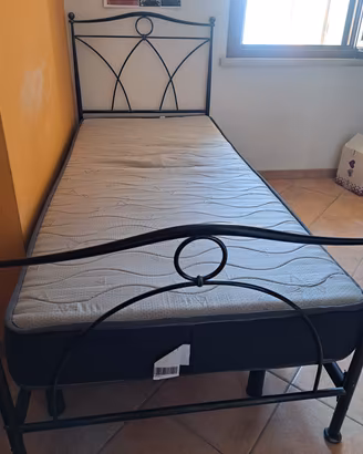 letto singolo in ferro battuto munito di rete e 
