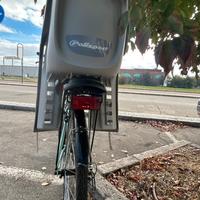 Bici donna dotata di cestino e seggiolino bimbo