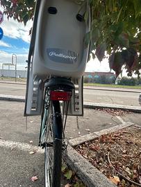 Bici donna dotata di cestino e seggiolino bimbo