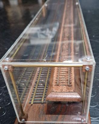 Teca in plexiglass con telaio e base in legno.