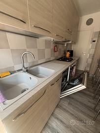 Cucina KOK con tavolo snack e elettrodomestici