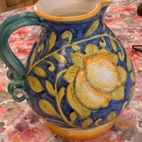 Una brocca dipinta a mano e due tendine bianche