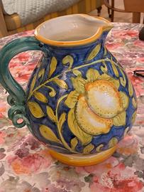 Una brocca dipinta a mano e due tendine bianche