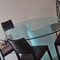 tavolo ovale in vetro lucido con base opaca.