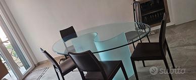 tavolo ovale in vetro lucido con base opaca.