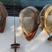 tre antiche maschere da scherma e due fioretti