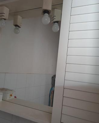 Pensile bianco da bagno con specchio.