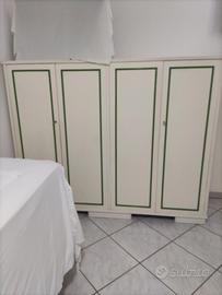 Armadio a 4 ante in legno con cornicette verdi.