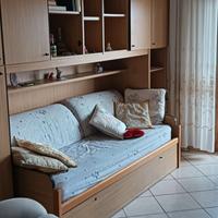 Parete attrezzata con letto singolo e armadi