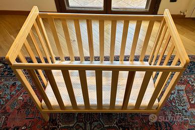 Lettino in legno e materasso.