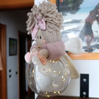 Bambola su pallina natalizia con luci