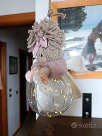Bambola su pallina natalizia con luci