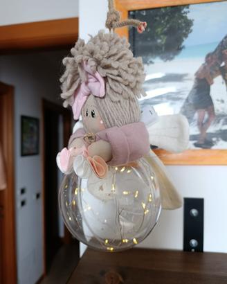 Bambola su pallina natalizia con luci