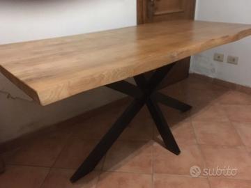 Tavolo moderno con gambe nere incrociate.