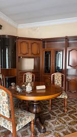 Salotto con tavolo e sedie e parete attrezzata