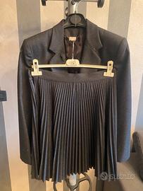 Abito da donna grigio con gonna a plissé