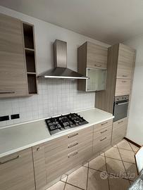 Cucina angolare moderna con elettrodomestici.