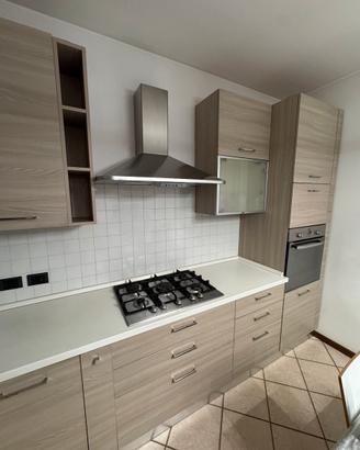 Cucina angolare moderna con elettrodomestici.
