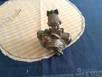 Statuetta in peltro vintage, ragazza con fiori.
