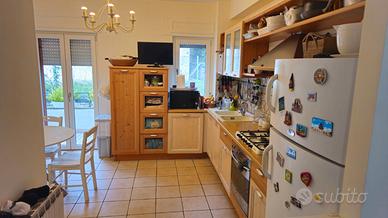 Cucina con elettrodomestici, tavolo e 4 sedie