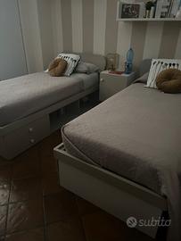 coppia di letti singoli con libreria e cassetti