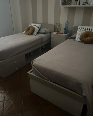 coppia di letti singoli con libreria e cassetti