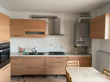 Cucina con elettrodomestici e mobilia