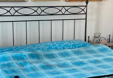 Letto matrimoniale con due comodini e materasso