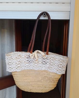 Borsa in paglia con manici in pelle.