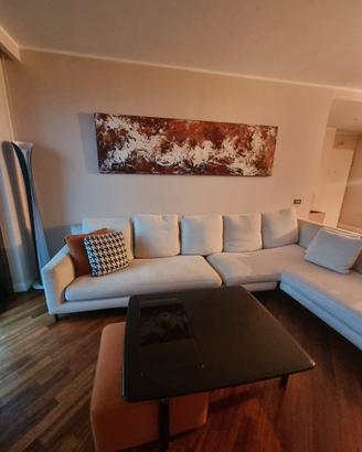 divano Minotti a L , tavolo e pouf color corallo 