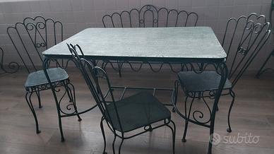 Tavolo da giardino con sedie, panca e carrello.