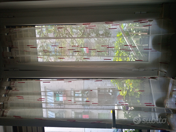 Tende bianche e rosse per finestra