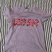 T-shirt lilla “LESS EGO” con stampa floreale