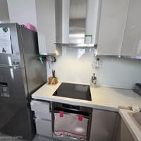 Cucina  angolare con elettrodomestici e frigo.