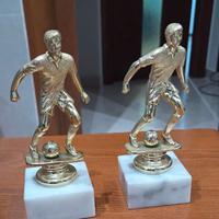 Coppa trofeo calcio color oro su base di marmo.
