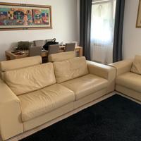 Coppia divani in pelle beige con puf