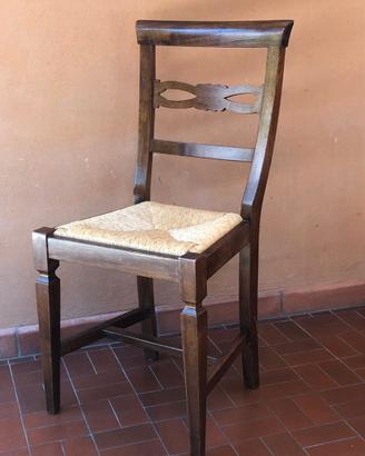 Serie di quattro sedie in noce con seduta paglia.