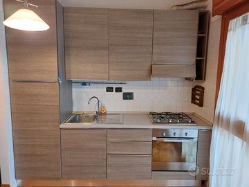 Cucina con frigo, forno e fornelli