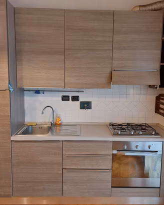 Cucina con frigo, forno e fornelli