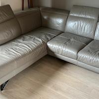 Divano in pelle ad angolo con segni di usura